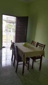uma mesa de jantar com 2 cadeiras e uma mesa com uma toalha de mesa em Villa Humaira Homestay - Cozy House for you em Pantai Cenang