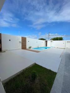 un edificio blanco con un patio con piscina en CASA K, en Barra de São Miguel