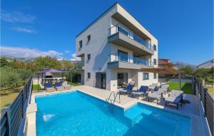 a house with a swimming pool next to a building at Stunning Home In Kastel Novi With 8 Bedrooms, Wifi And Outdoor Swimming Pool in Kaštela