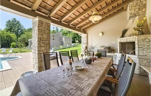 a dining room with a table and a fireplace at Lovely Home In Snasici With Sauna in Mali Turini