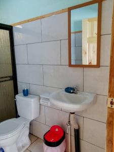 y baño con aseo, lavabo y espejo. en Casa Beli, en Monteverde