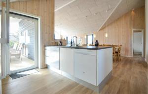eine Küche mit weißen Schränken und ein Esszimmer in der Unterkunft Lovely Home In Thisted With House A Panoramic View in Torsted