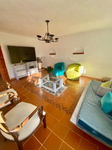 ein Wohnzimmer mit einem Flachbild-TV und Stühlen in der Unterkunft El Oasis de la villa in Villa de Leyva