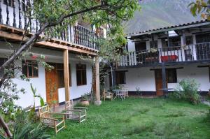 a house with chairs and tables in the yard at Las Orquideas Ollantaytambo IN in Ollantaytambo