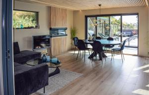 a living room with a couch and a table and chairs at Awesome Home In Brevik With Outdoor Swimming Pool in Bjønnes