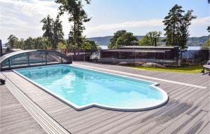 a swimming pool on the deck of a house at Stunning Home In Brevik With Outdoor Swimming Pool, Sauna And Private Swimming Pool in Bjønnes