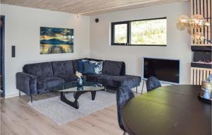 a living room with a couch and a table at Awesome Home In Brevik With Outdoor Swimming Pool in Bjønnes