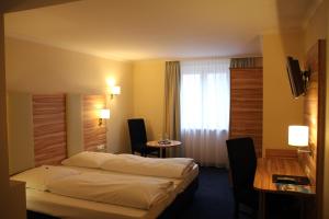Habitación de hotel con cama y mesa en Hotel Daniel, en Múnich