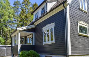 a house with black siding and white windows at 2 Bedroom Cozy Home In Halden in Halden