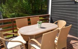 a table and chairs on a porch with a potted plant at 2 Bedroom Cozy Home In Halden in Halden