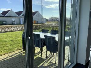 una mesa y sillas en un balcón con vistas a un campo en Holiday home Thyholm XXVII en Thyholm