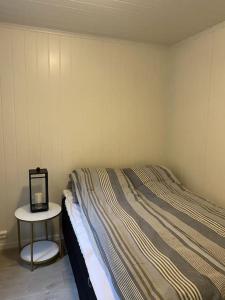 1 dormitorio con cama y mesa pequeña en Helt ny rorbu på Slyngstad i Ålesund Kommune, en Ålesund