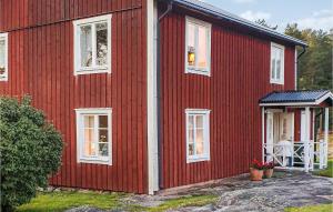 a red house with white windows and a table at Gorgeous Home In Finnestad With Wifi in Säffle