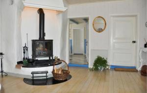 Gorgeous Home In Finnestad With Wifi في سيفلي: غرفة معيشة مع موقد خشبي في غرفة