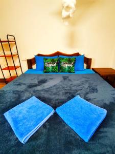 a bed with blue sheets and blue pillows on it at Long beach simple House in Ko Lanta