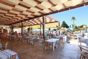 an outdoor restaurant with tables and chairs and people at Makronisos Village in Ayia Napa