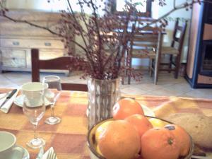 a table with a bowl of oranges and a vase at Agriturismo il Mercante in San Martino