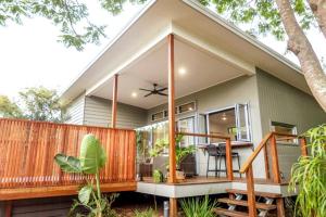 a home with a large glass door on a deck at Beach House with spa among the trees Coolum Beach in Coolum Beach