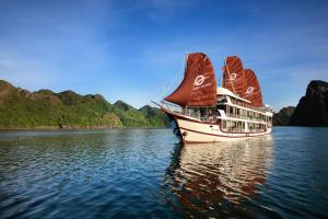 un barco con una vela grande en el agua en V'Spirit Cruise en Ha Long