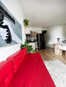 un sofá rojo en la sala de estar con una alfombra roja en Hermoso Apartamento en el Mejor Barrio de Bogotá, en Bogotá