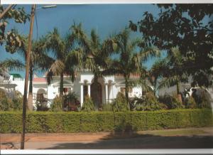 a white house with palm trees in front of it at Kunjpur Heritage in Allahābād