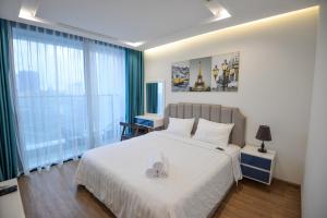 a bedroom with a white bed and a window at La Rosa Vinhomes Metropolis in Hanoi