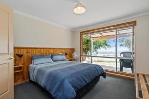 ein Schlafzimmer mit einem Bett und einem großen Fenster in der Unterkunft Augusta Sheoak Chalets in Augusta