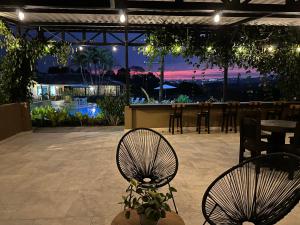 a patio with two chairs and a bar at night at Baum Hotel in Armenia