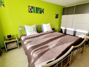 een slaapkamer met een groot bed met groene muren bij Gîte Bailleul, 4 pièces, 6 personnes - FR-1-510-176 in Bailleul