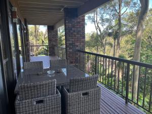 porche con mesa y sillas en el balcón en Palm beach Sydney, Modern home with water view, en Palm Beach
