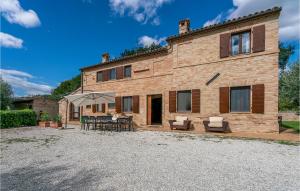 een groot bakstenen huis met een tafel en stoelen bij Villa Dei Girasoli in Petriolo