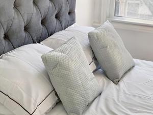 un letto bianco con due cuscini sopra di Modern Room in Centrally Located Apartment - Room 4 a Londra