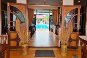 an open door to a house with a pool at Meyers Hua Hin in Hua Hin