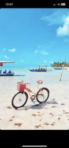 a bike with a basket parked on a beach at MAKAI Milagres in São Miguel dos Milagres