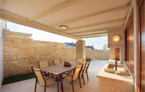 a patio with a table and chairs and a stone wall at Lovely Home In Vabriga With Kitchen in Vabriga