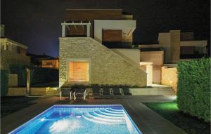 a swimming pool in front of a house at night at Lovely Home In Vabriga With Kitchen in Vabriga