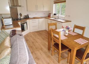 a kitchen and dining room with a table and a couch at Clun Valley Lodges in Clunton