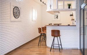 eine Bar mit Hockern in einer Küche mit weißen Wänden in der Unterkunft Cozy Home In Pleternica With Private Swimming Pool, Can Be Inside Or Outside in Velika