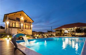 ein Schwimmbad vor einem Haus in der Nacht in der Unterkunft Cozy Home In Pleternica With Private Swimming Pool, Can Be Inside Or Outside in Velika