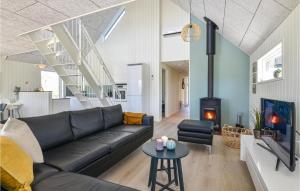 a living room with a black couch and a fireplace at Stunning Home In Skjern With Kitchen in Skjern