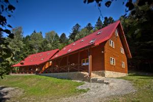 un grande fienile in legno con tetto rosso di Domki na Górce a Wierchomla Mała