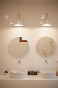 two mirrors on a white wall with two sinks at Chao Sam Ran Pool Villa Phetchaburi หาดเจ้าสำราญ เพชรบุรี ราคาสำหรับ 8 ท่าน in Haad Chao Samran