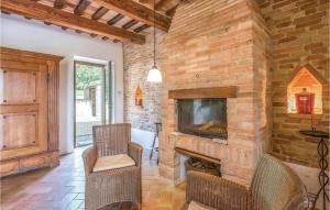 a living room with a stone fireplace and a tv at Casa Panorama in Ostra Vetere