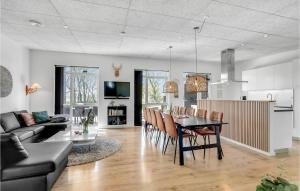 uma cozinha e sala de estar com mesa e cadeiras em Beautiful Home In Haderslev With Sauna em Knud