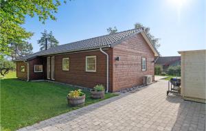 ein kleines Holzhaus mit zwei Topfpflanzen in einem Hof in der Unterkunft Lovely Home In Sklskr With Kitchen in Skælskør