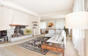 a living room with a white couch and a fireplace at Villa Oleandro in Fauglia