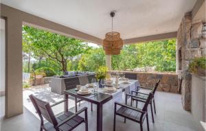 a dining room with a table and chairs on a patio at Beautiful Home In Naklice With Kitchen in Gata