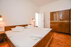 ein großes weißes Bett in einem Zimmer mit Holzböden in der Unterkunft House Periska in Mrljane