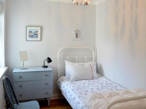 een slaapkamer met een bed en een dressoir met een lamp bij Buzzards - 8235 in Bridport
