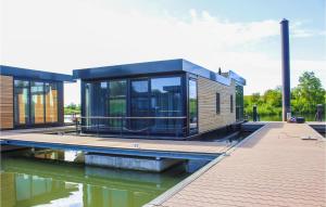 a house on the water with a dock at Hausboot Bellevue in Ohé en Laak